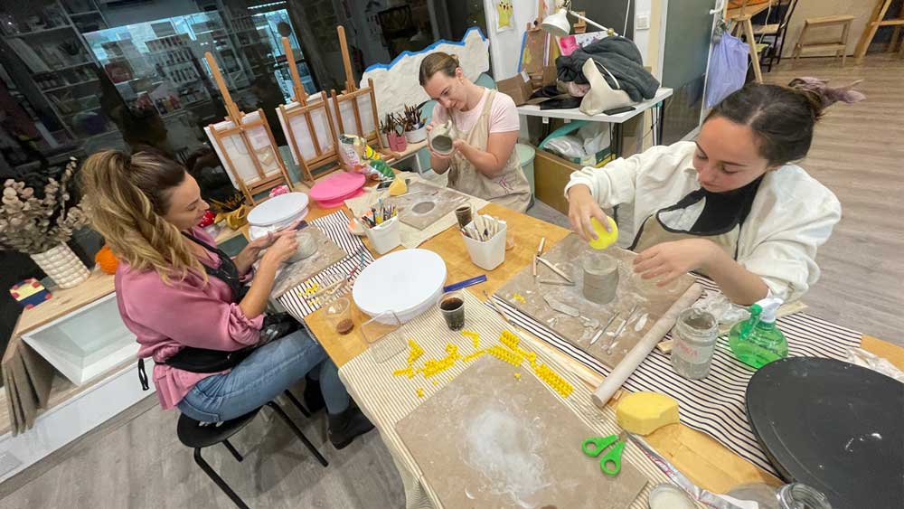 Alumna trabajando con torno en clase de cerámica para adultos